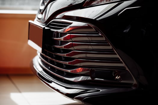 bumper of new luxury black car in salon, Titanium equipment, Led headlights dynamic drive, parking sensors, silver front grille mounted photo