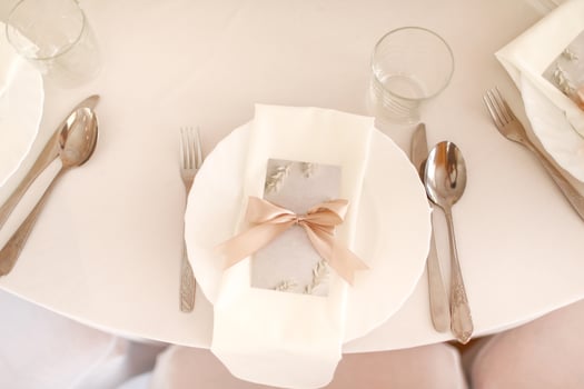 Wedding table setting with white plate, glasses and silver cutlery. mockup blank with pink ribbon on plate photo