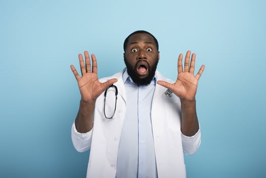 Doctor is afraid due to codiv19 virus attack. Cyan background photo