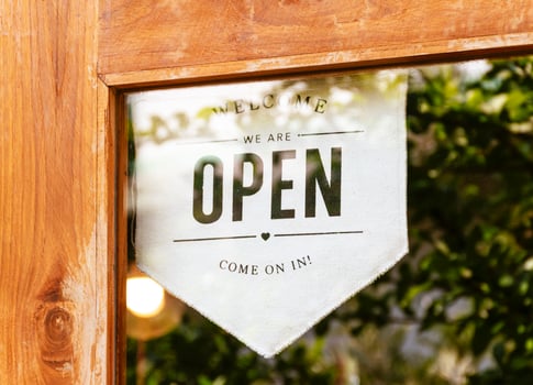 Hanging sign with message Welcome OPEN on glass door at coffee shop photo