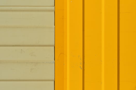 Gray and bright yellow warehouse wall made of profiled metal wall, background ideas for a screen or design articles photo