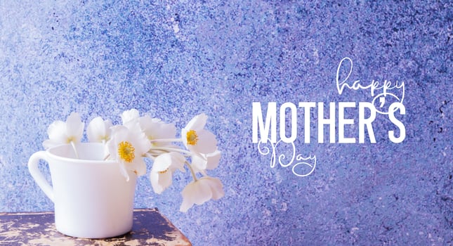 Anemones flower bouquet in a cup and vinage book. Happy Mother's Day greeting text photo
