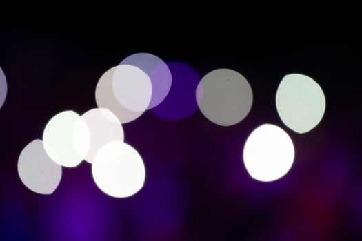 White spots blur bokeh on a black background. photo