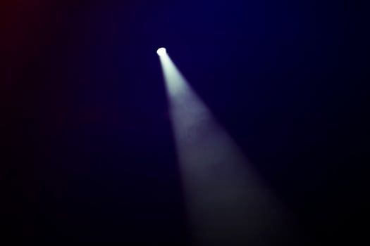 White smoky beam of stage light on a dark background. photo