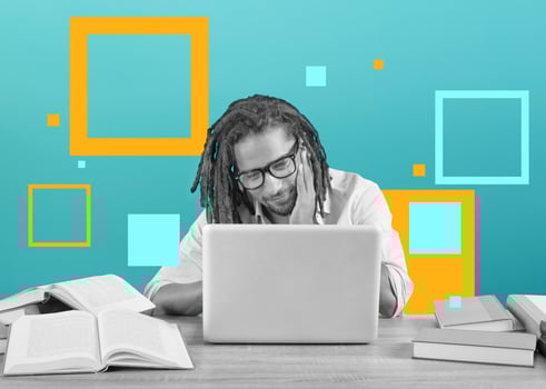 Student studies with his laptop with a desk full of books. Concept on online exam photo