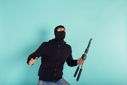 Thief with balaclava acts in silence to steal apartments with wire cutters in hand photo