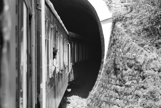 Toy Train moving on mountain slope, beautiful view, 1 side mountain, 1 side valley moving on railway to the hill, among green natural forest. Toy train from Kalka to Shimla in India-Black and White photo