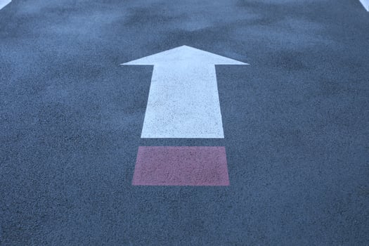 White and red direct arrow on asphalt street. Direction indicator. Signs on the street. photo