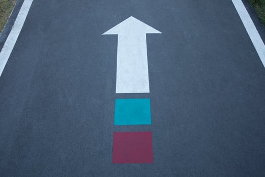 White arrow sign with green and red on the end. photo