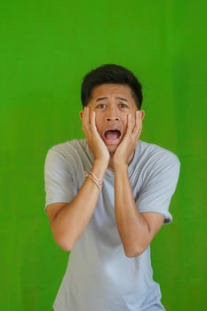 expressive casual Balinese Asian guy model for advertising with green screen studio background photo