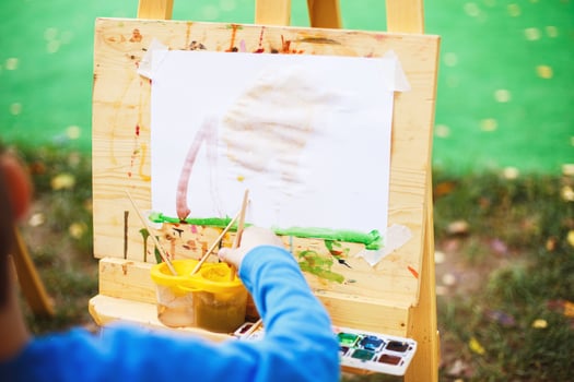 boy draws  on the easel. the child paints photo