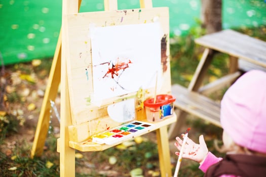 little girl draws  on the easel. the child paints photo