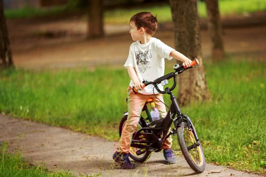 the boy is riding a bike on the street photo