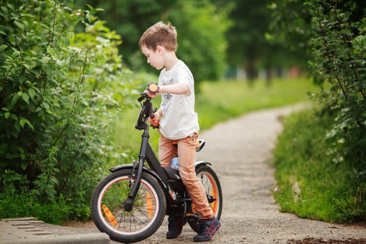 the boy is riding a bike on the street photo