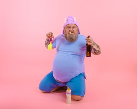 Fat angry man acts like a angry baby but drinks beer photo