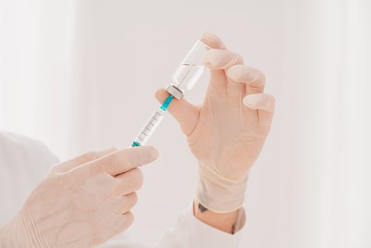 Doctor with syringe is ready to administer the vaccine against covid-19 photo