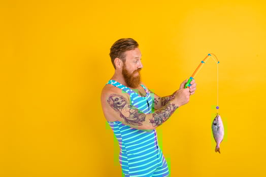 man with beard and swimsuit caught a fish photo