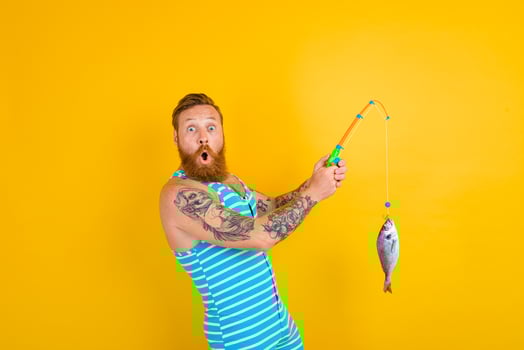 man with beard and swimsuit caught a fish photo