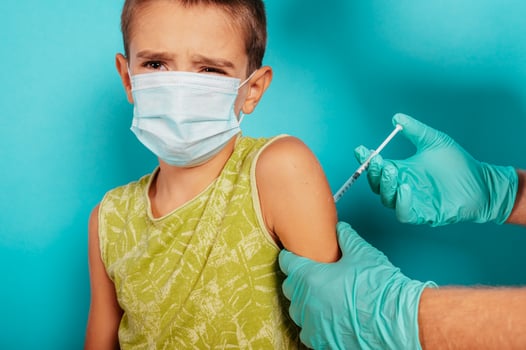 Doctor injects vaccine to a child against covid19 coronavirus photo