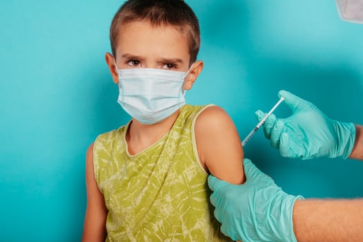 Doctor injects vaccine to a child against covid19 coronavirus photo