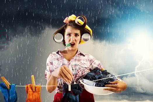 Unhappy housewife hangs clothes and it starts to rain photo