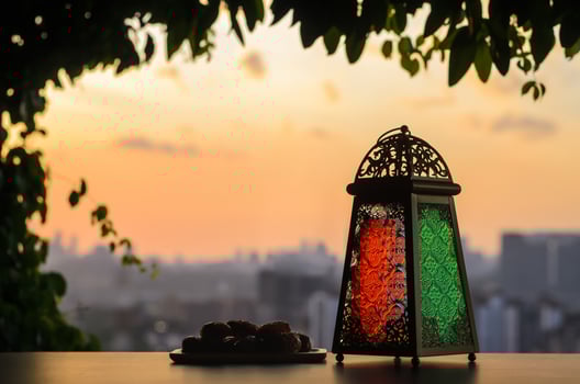 Lantern and dates fruit with dusk sky and city background for the Muslim feast of the holy month of Ramadan Kareem. photo