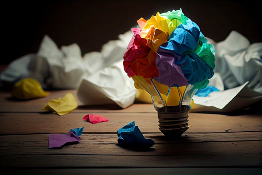 great idea concept with crumpled colorful paper and light bulb on wooden table photo