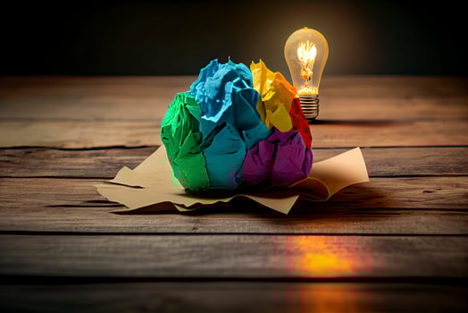 great idea concept with crumpled colorful paper and light bulb on wooden table photo