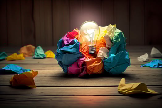 great idea concept with crumpled colorful paper and light bulb on wooden table photo