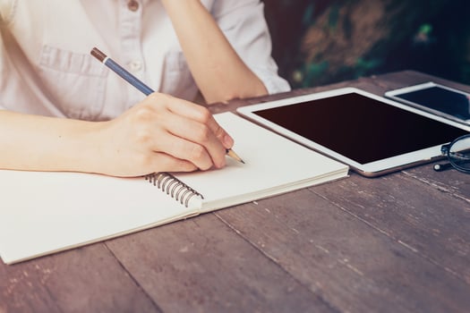 Close up hand woman writing notebook on wood table. photo