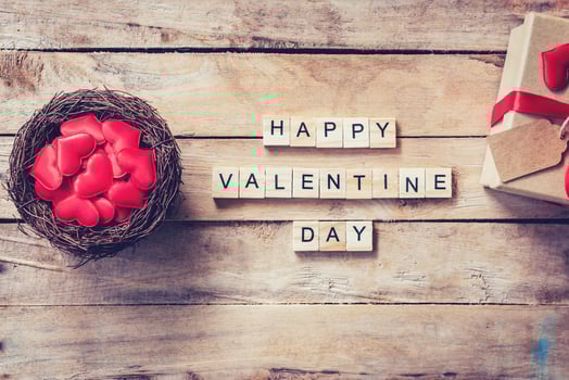 Gift box and red heart in nest with wooden text Happy Valentine Day on wood table background. photo