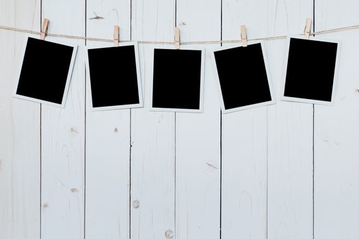 five photo frame blank hanging on wooden board background.