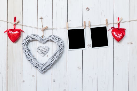 wooden rustic decorative hearts and photo frame hanging on vintage wooden background with space.