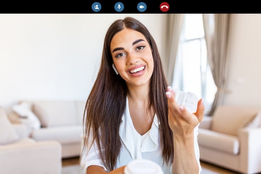 Attractive young woman smiling and looking at camera while having video call. Online teaching. Young woman wearing headphone photo