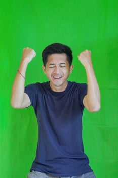 expressive casual Balinese Asian guy model for advertising with green screen studio background photo