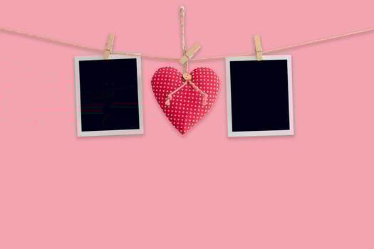 Blank instant photos and red heart hanging pastel color background.