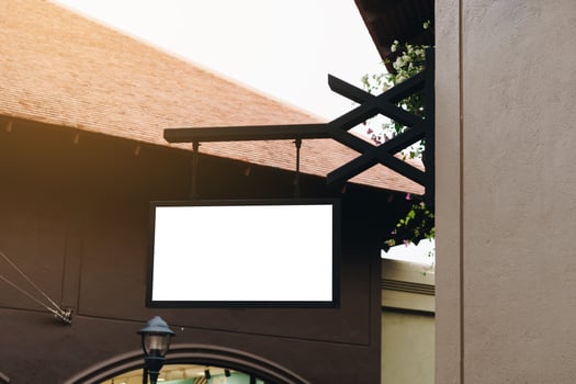 Empty signage and blank mock up hanging on street with copy space photo