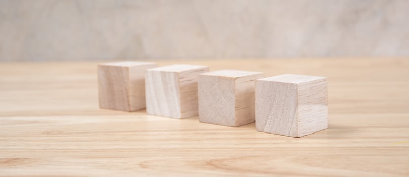 Wooden toy cubes on wooden table ang grey background photo