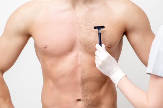 Beautician shaves chest of young man photo