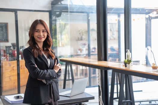 Marketing, Financial, Accounting, Planning, Smiling businesswoman standing with arms crossed happily leading a profitable business management team inside the office. photo