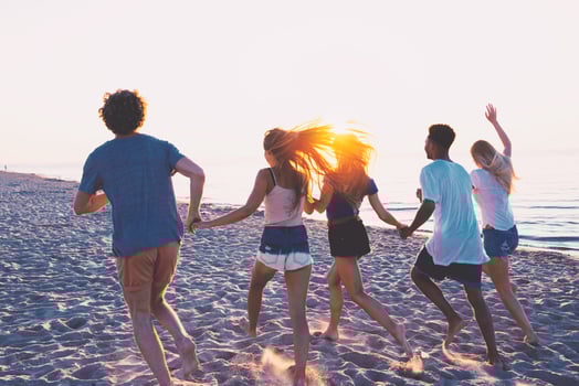Group of happy friends having fun at ocean beach photo