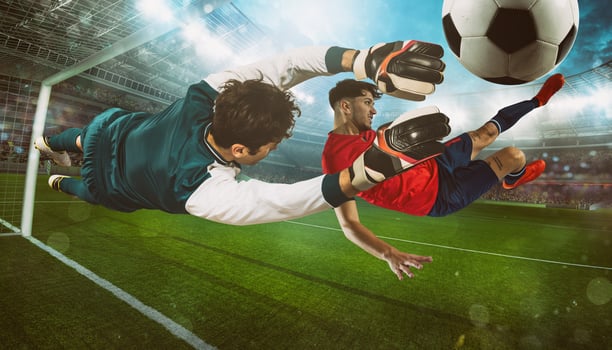 Soccer striker in red uniform hits the ball with an acrobatic kick at the stadium photo