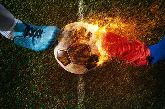 Two soccer players challenge each other at the stadium ready to kick a fiery ball photo