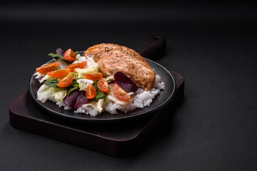 Delicious healthy breakfast consisting of chicken, rice, greens and cherry tomatoes photo