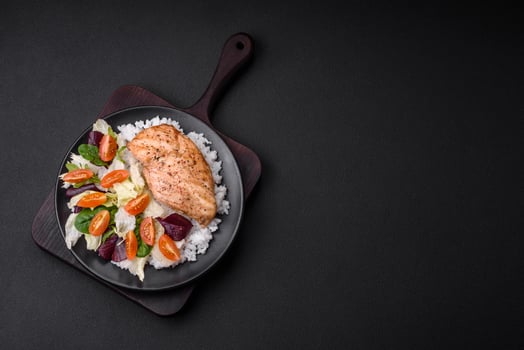 Delicious healthy breakfast consisting of chicken, rice, greens and cherry tomatoes photo