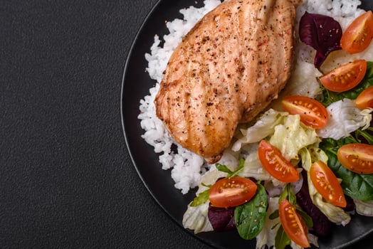 Delicious healthy breakfast consisting of chicken, rice, greens and cherry tomatoes photo