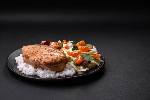 Delicious healthy breakfast consisting of chicken, rice, greens and cherry tomatoes photo