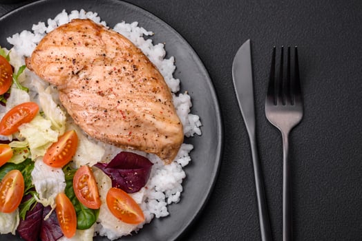 Delicious healthy breakfast consisting of chicken, rice, greens and cherry tomatoes photo
