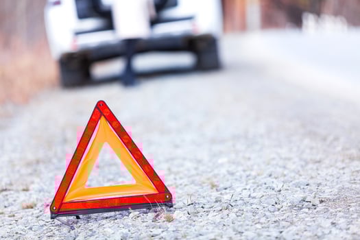 Closeup shot of warning red triangle sign, broken car and girl photo