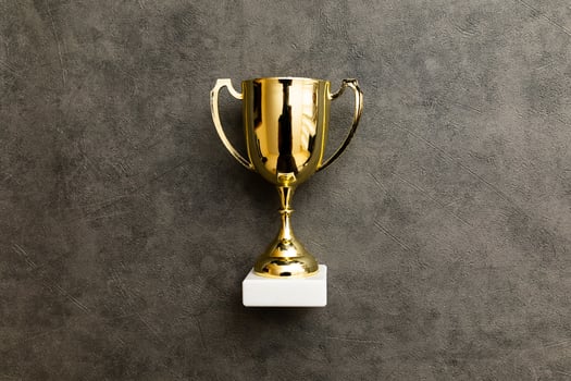 Simply flat lay design winner or champion gold trophy cup on concrete stone grey background. Victory first place of competition. Winning or success concept. Top view copy space. photo